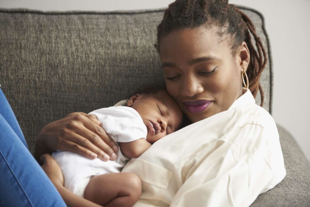 black mother cuddling sleeping baby son on sofa 758282421 5b1a841f8e1b6e0036b6face
